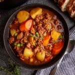 A bowl of Vegan Chorizo Stew, garnished with fresh thyme.
