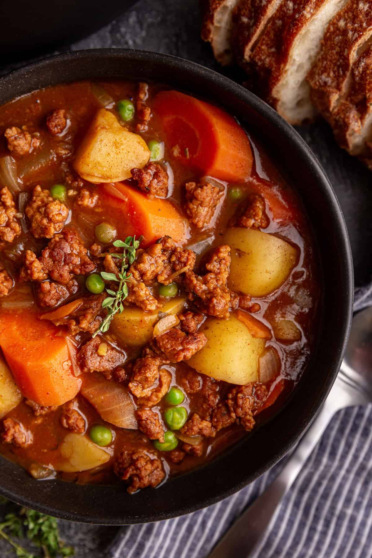 A bowl of Vegan Chorizo Stew, garnished with fresh thyme.