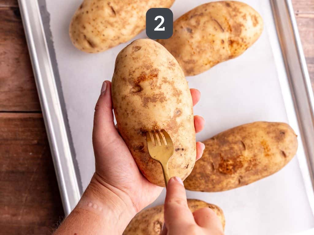 Vegan loaded baked potatoes step - 2 fork the potatoes.
