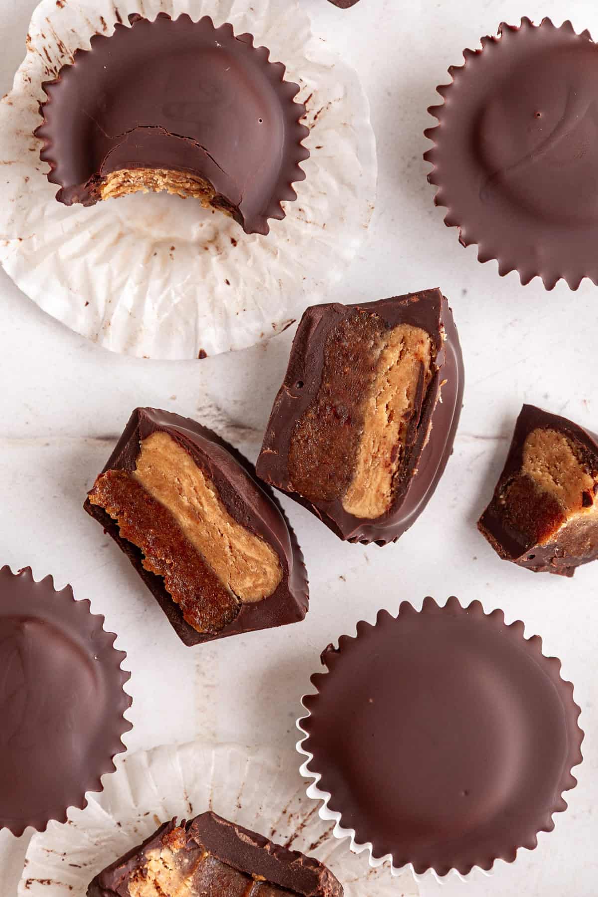 Several Vegan Reeses Caramel Big Cups cut to show the caramel and peanut butter layers.
