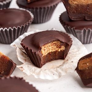 A bite taken out of a Vegan Reeses Caramel Big Cup to show the caramel and peanut butter layers.