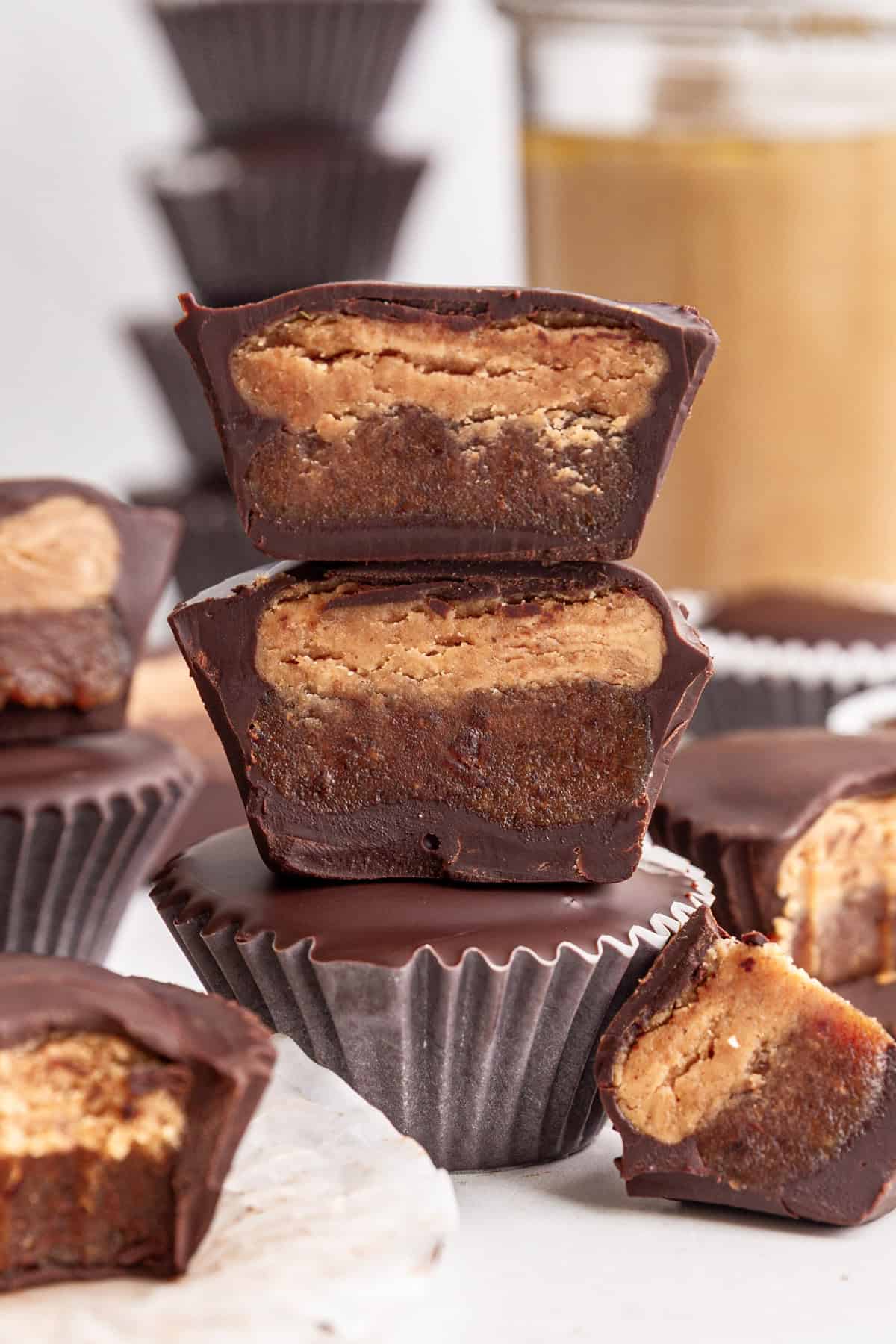 Several Vegan Reeses Caramel Big Cups cut to show the caramel and peanut butter layers.