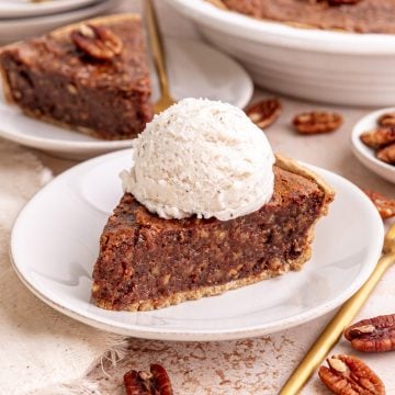 A slice of vegan pecan pie, topped with a scoop of ice cream.