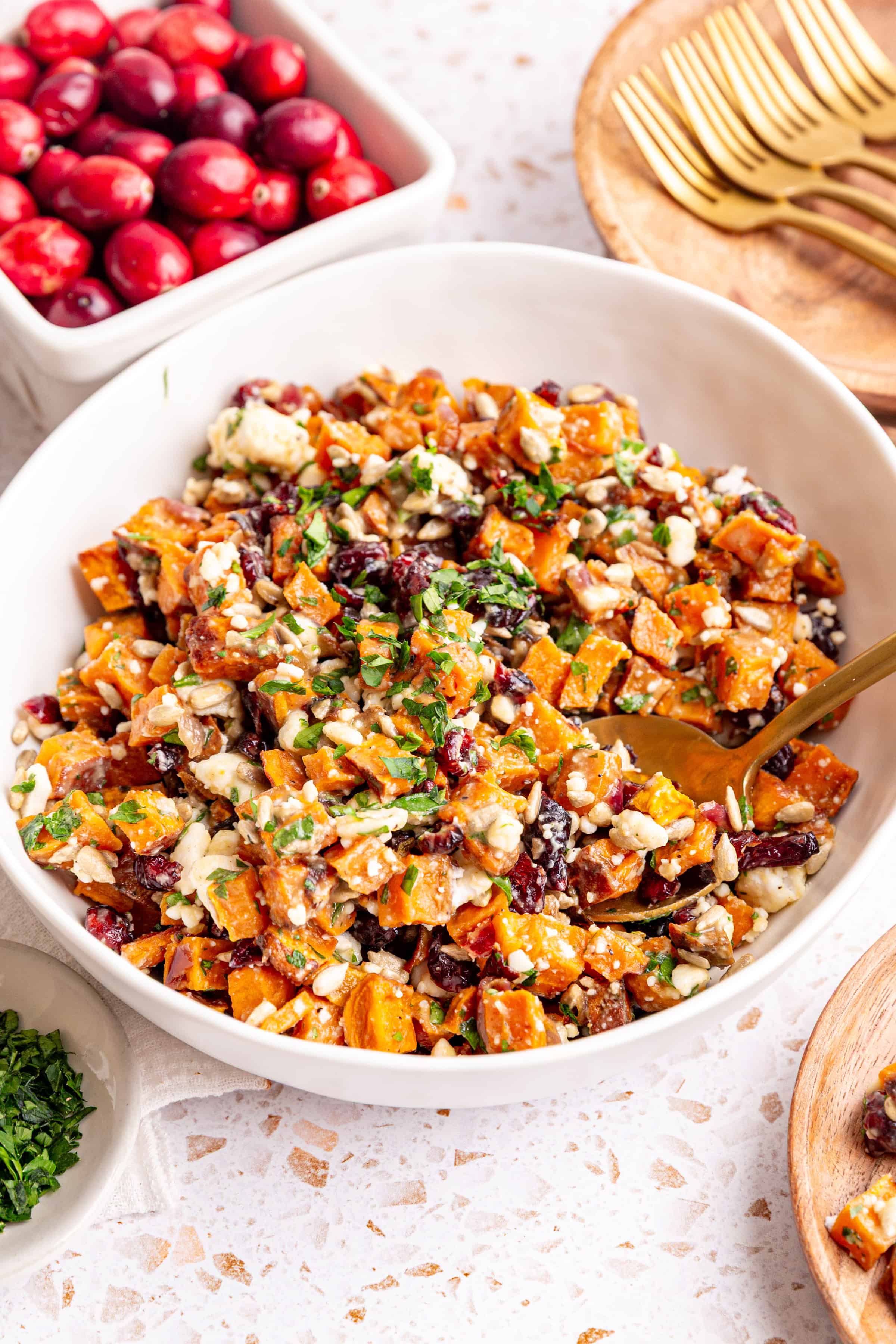 A bowl of Vegan Roasted Sweet Potato Salad with a spoon in it, ready to serve.