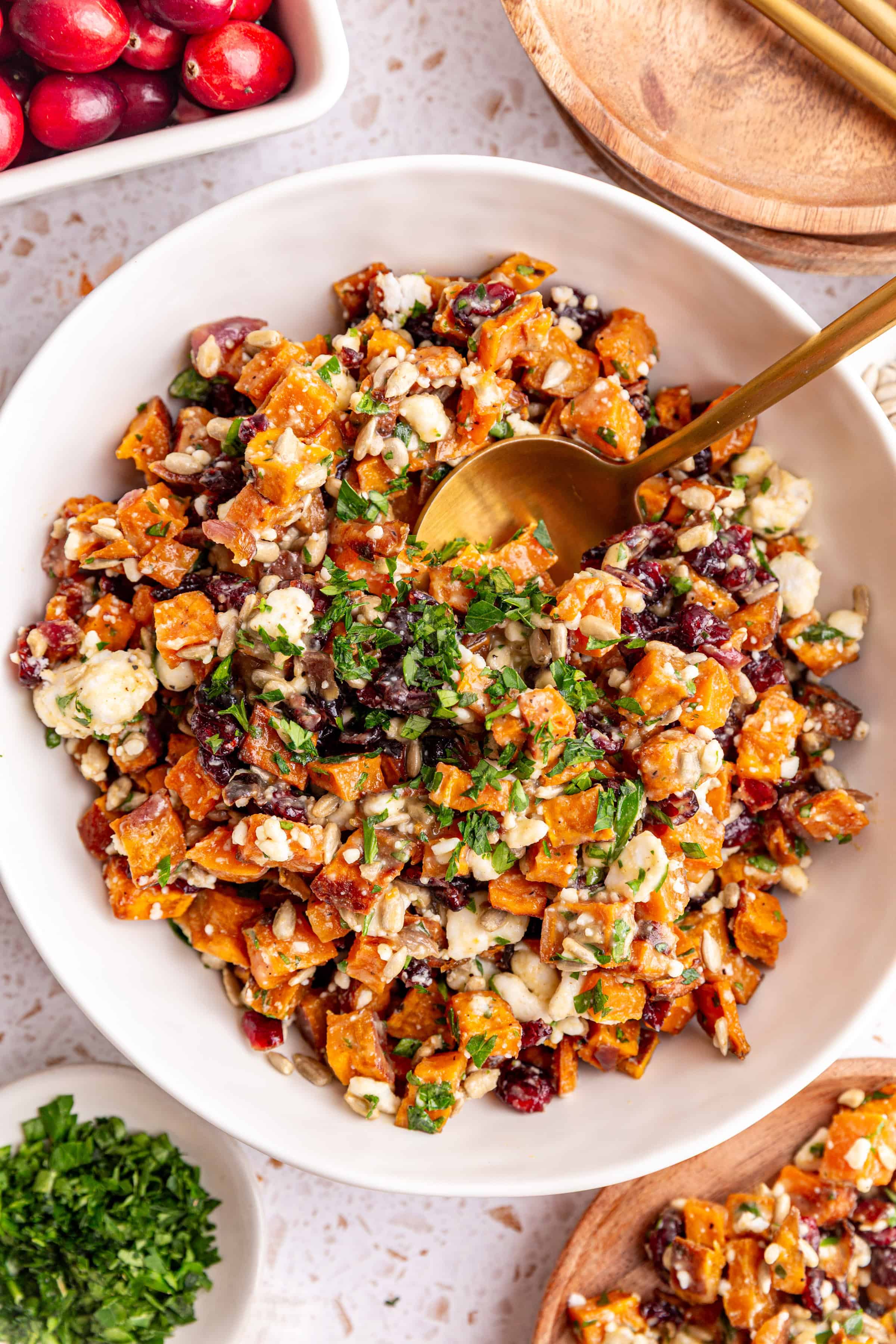 A bowl of Vegan Roasted Sweet Potato Salad with a spoon in it, ready to serve.