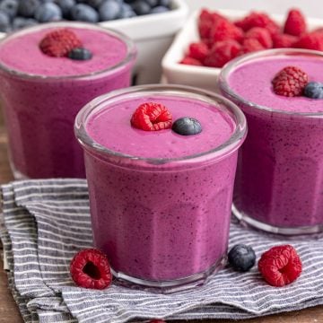 A Blueberry Raspberry Smoothie, garnished with a fresh raspberry and blueberry.