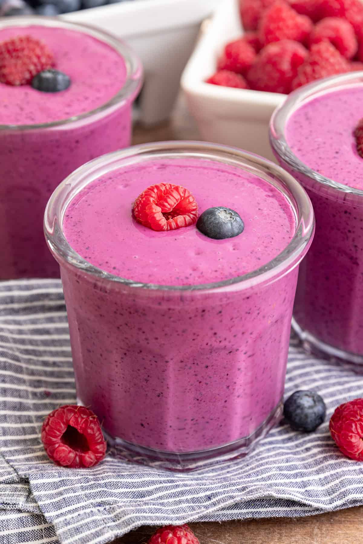 A Blueberry Raspberry Smoothie, garnished with a fresh raspberry and blueberry.