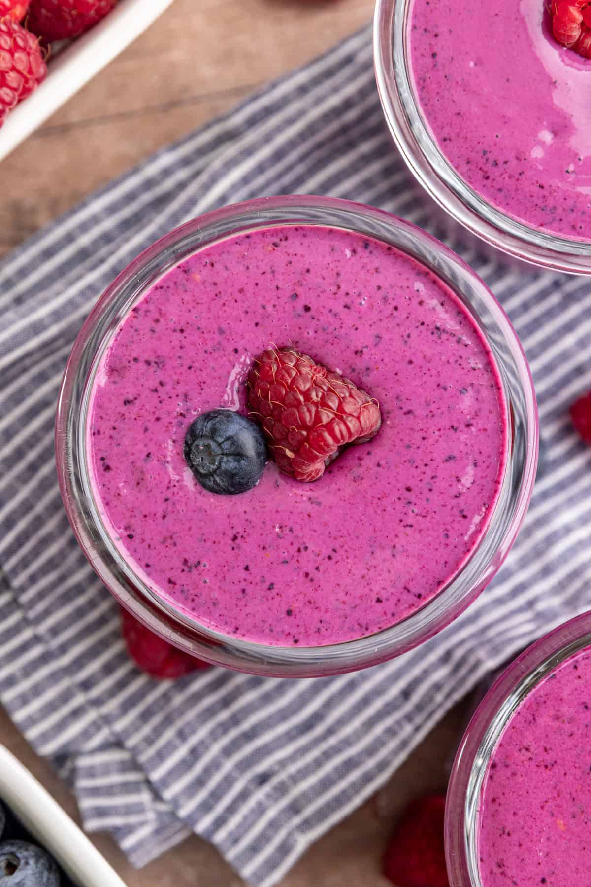 A top-down view of a Blueberry Raspberry Smoothie, garnished with a fresh raspberry and blueberry.
