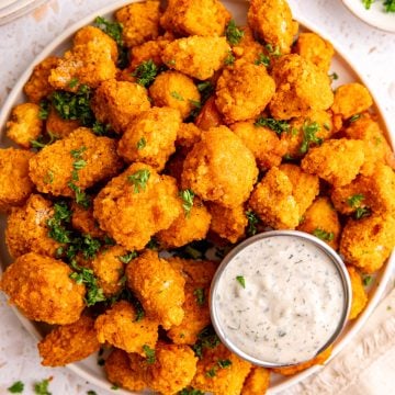 A plate of buffalo tofu poppers with a container of vegan ranch.
