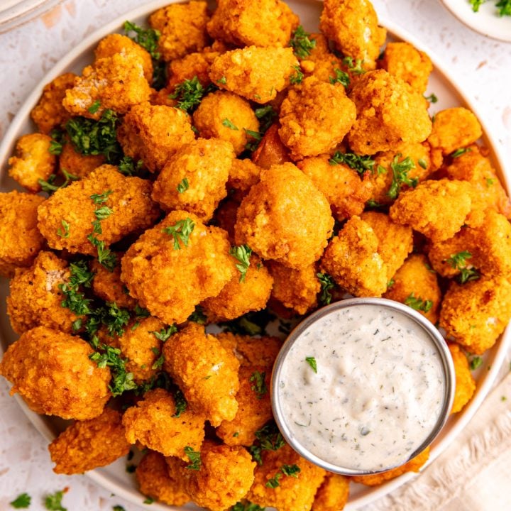A plate of buffalo tofu poppers with a container of vegan ranch.