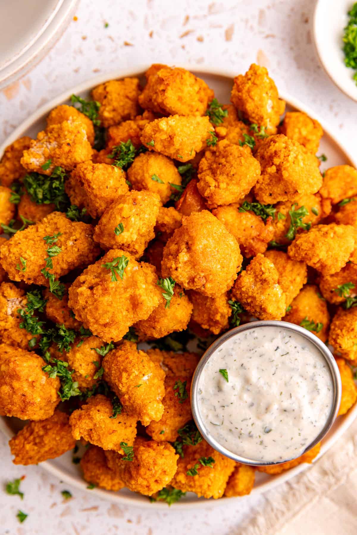 A plate of buffalo tofu poppers with a container of vegan ranch.