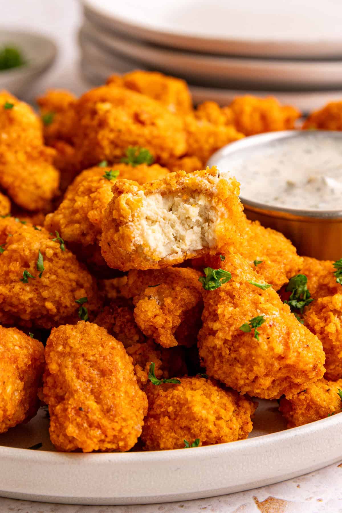 A buffalo tofu popper with a bite taken from it to show the nugget like texture.