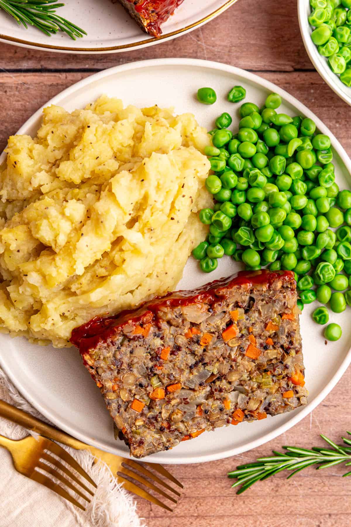 A plate of lentil quinoa loaf, mashed potatoes, and peas.