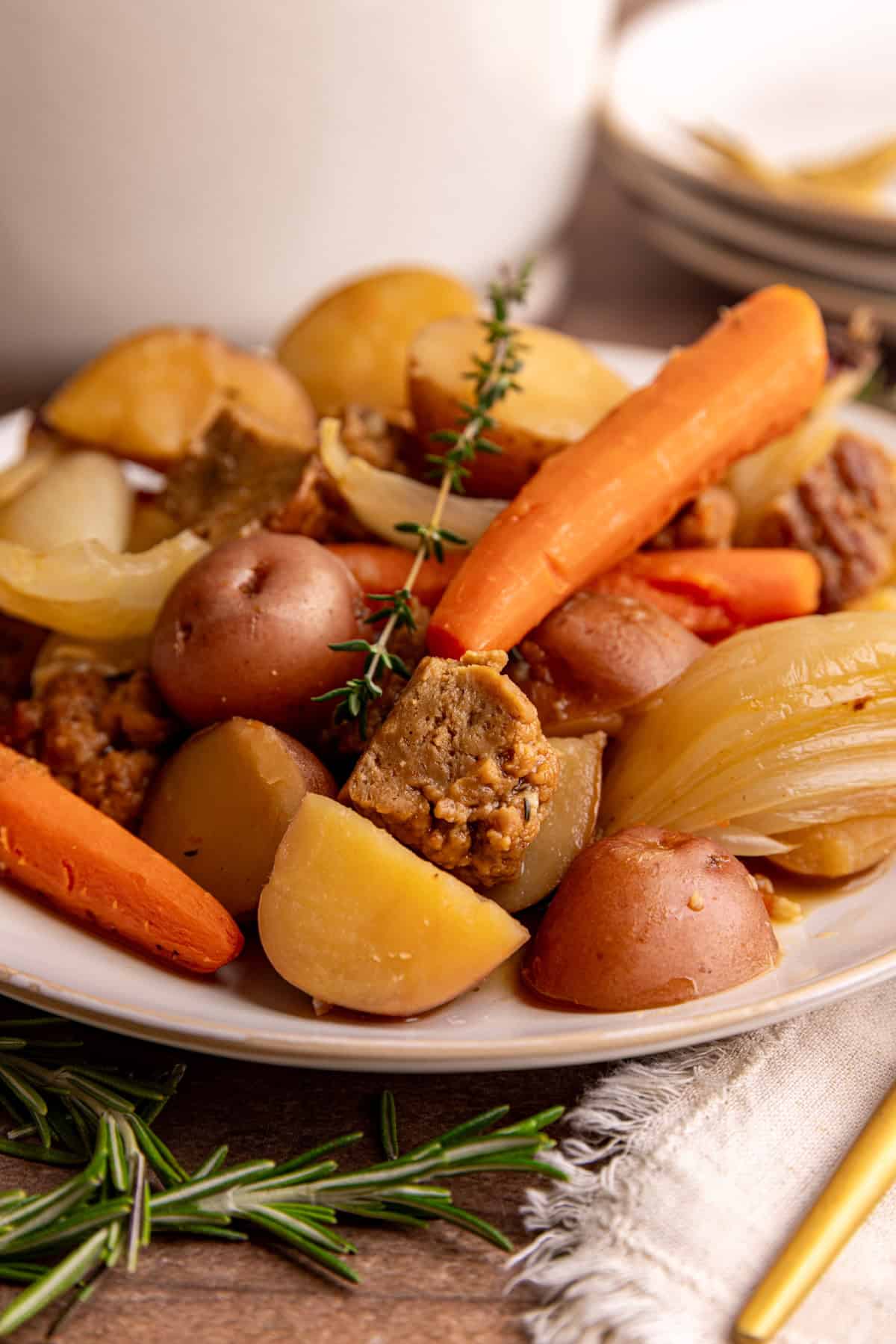 A plate of vegan pot roast, garnished with fresh thyme.