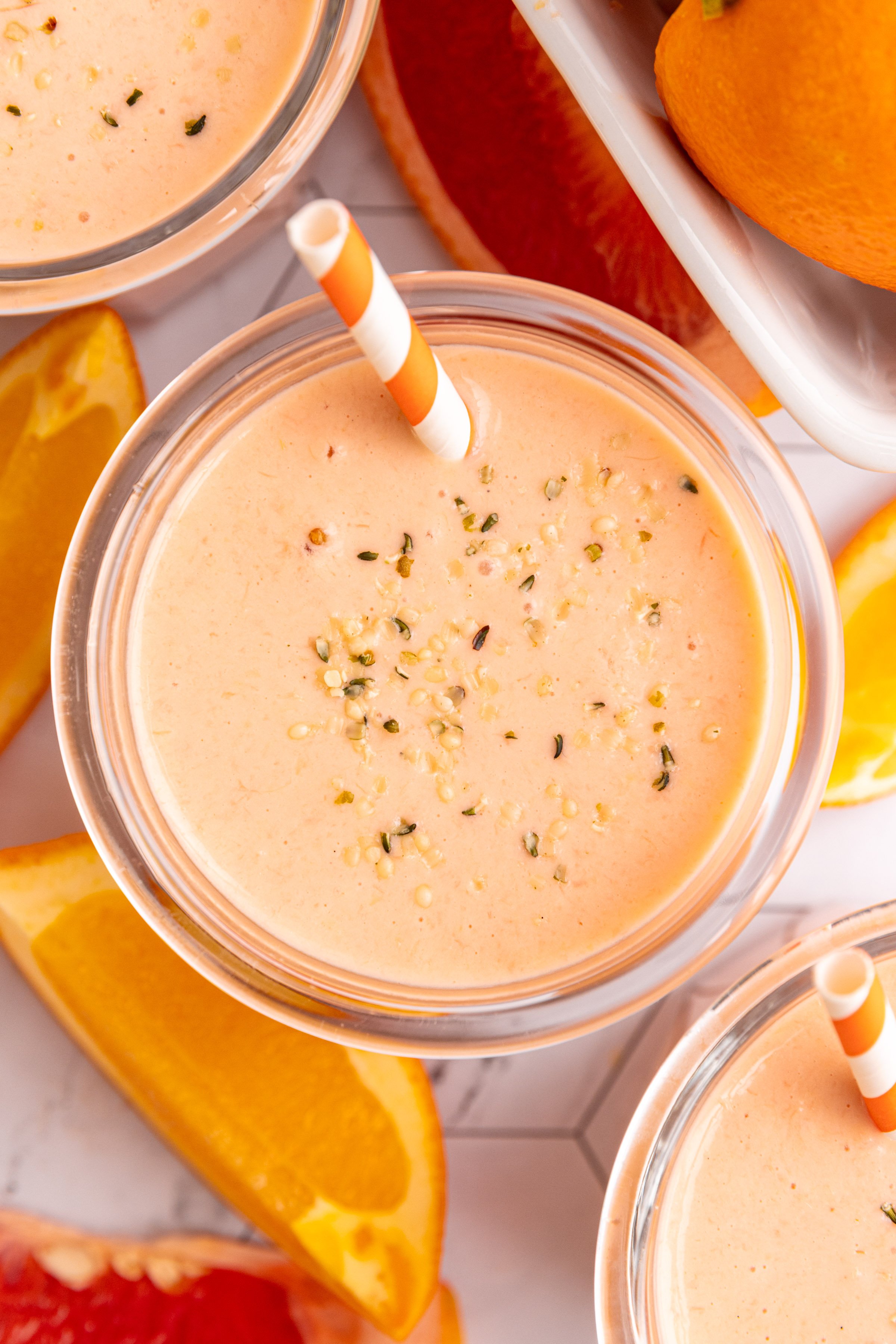 A top down view of three citrus smoothie glasses.