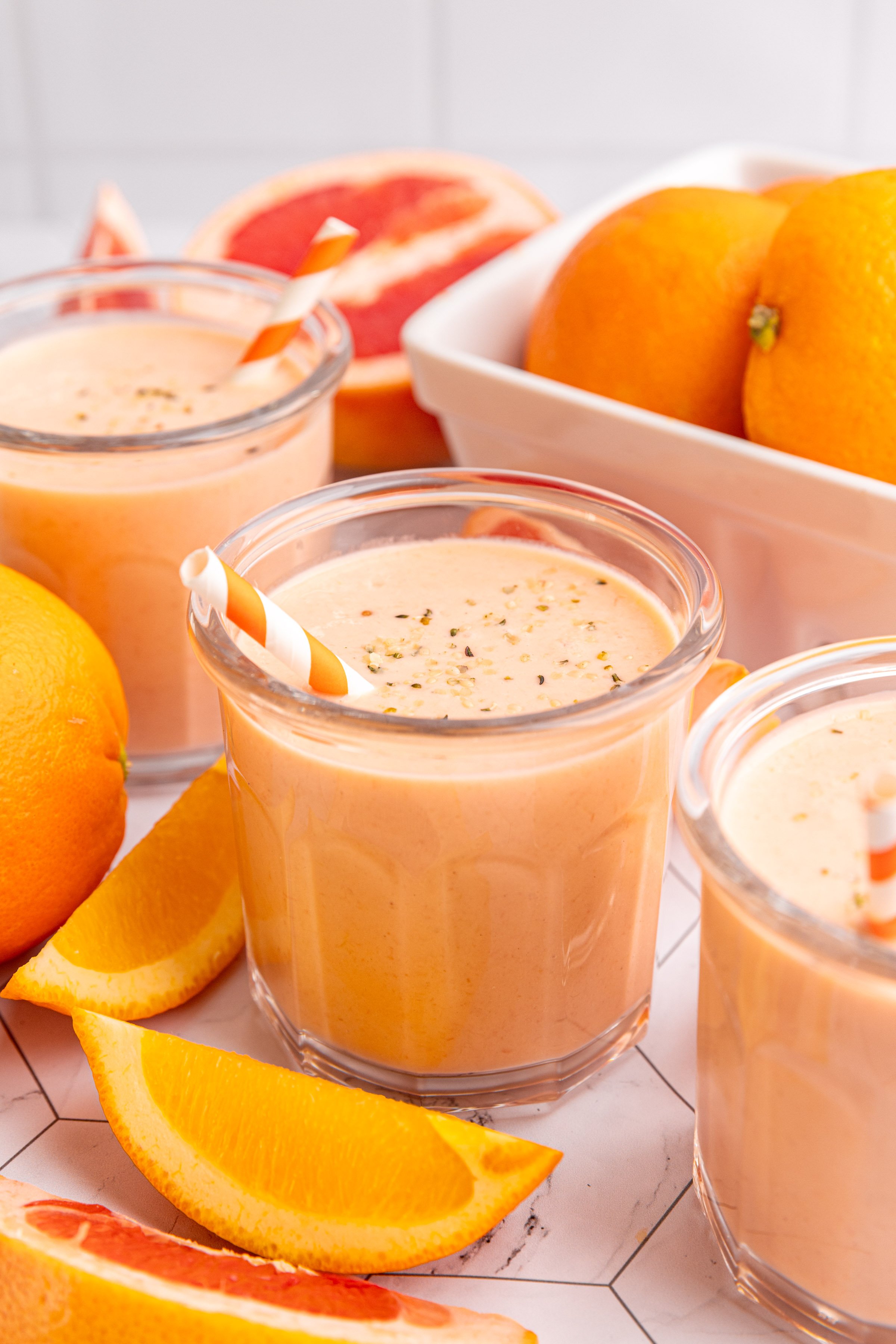 Three Citrus Smoothie glasses with slices of oranges and grapefruits.