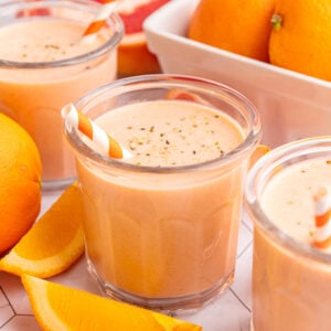 Three Citrus Smoothie glasses with slices of oranges and grapefruits.