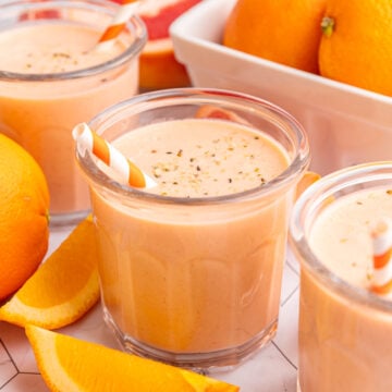 Three Citrus Smoothie glasses with slices of oranges and grapefruits.