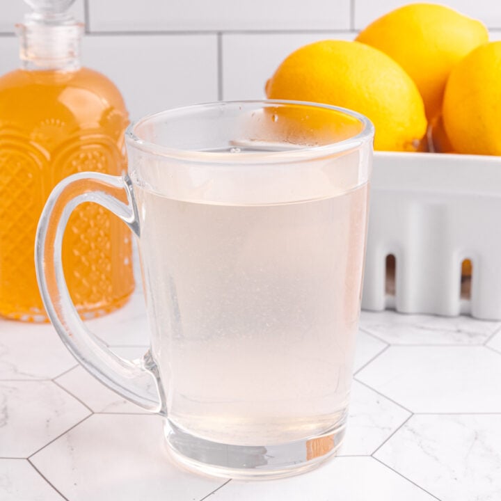 A glass of lemon ginger tea on a countertop.