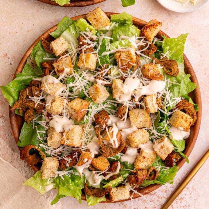 A Vegan chicken caesar salad, with a fork, ready to serve.