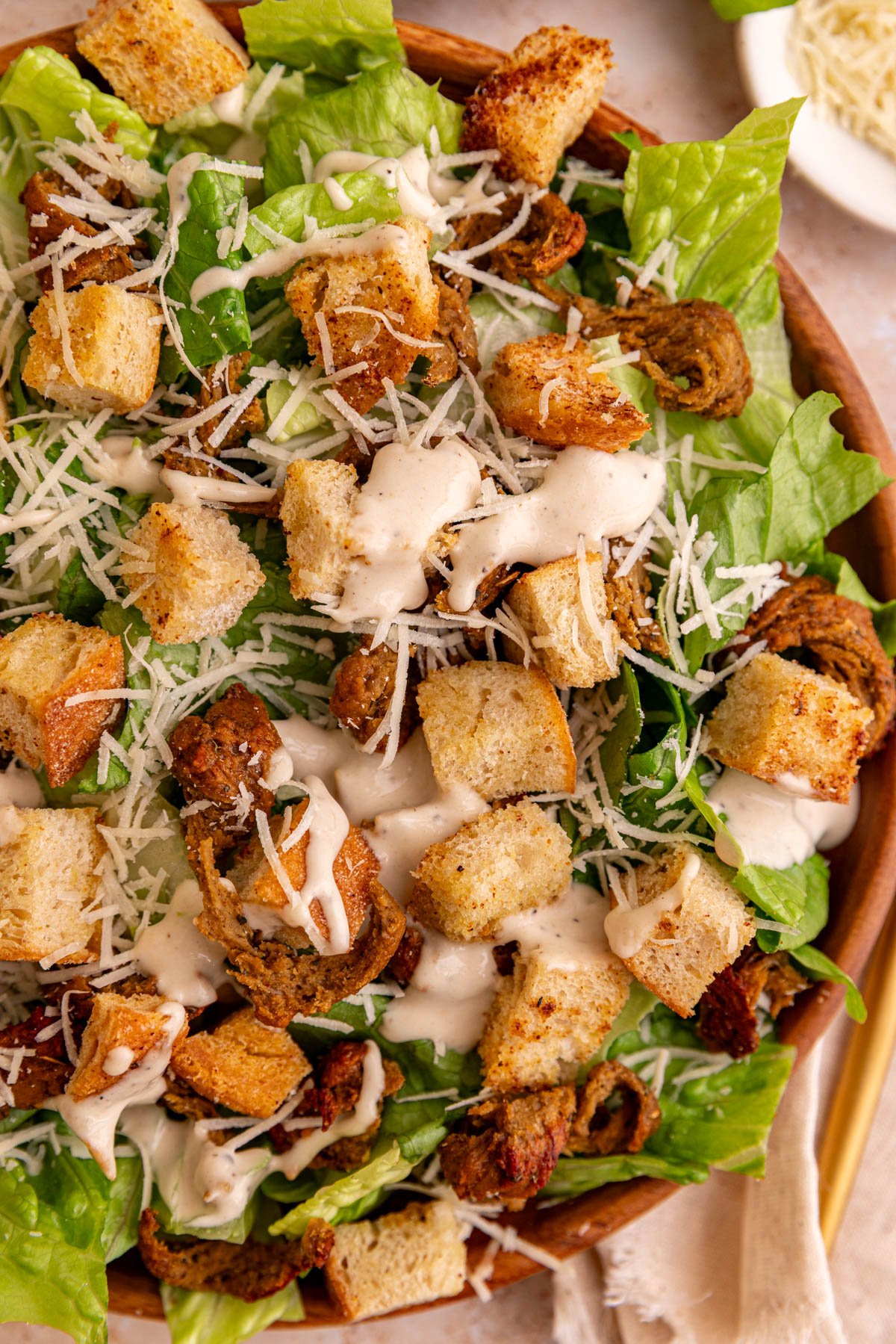 A plate of vegan chicken caesar salad made with seitan chicken and croutons,
