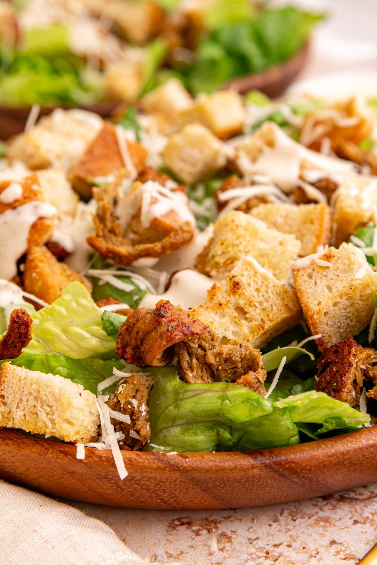 A plate of vegan chicken caesar salad made with seitan chicken.