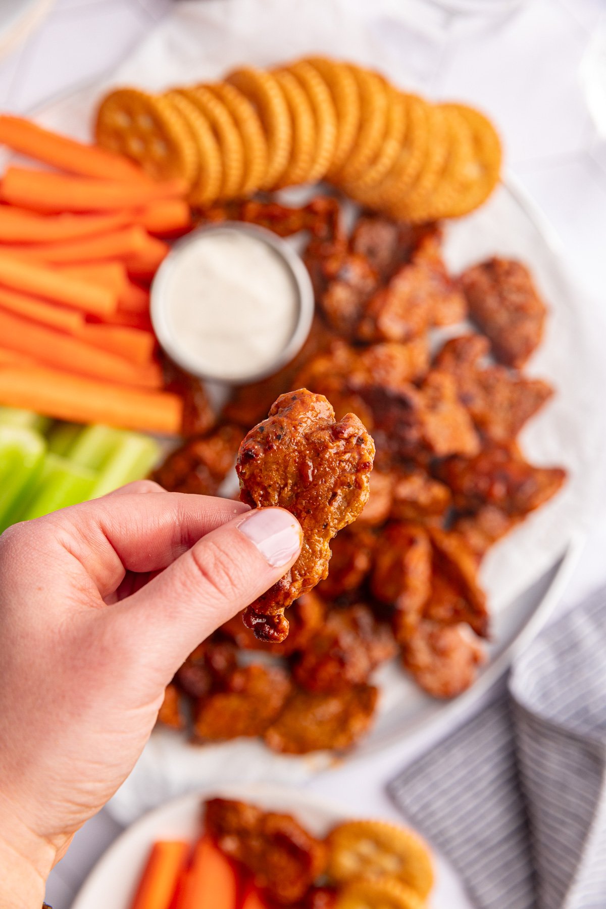 A hand holding a vegan seitan buffalo wing.