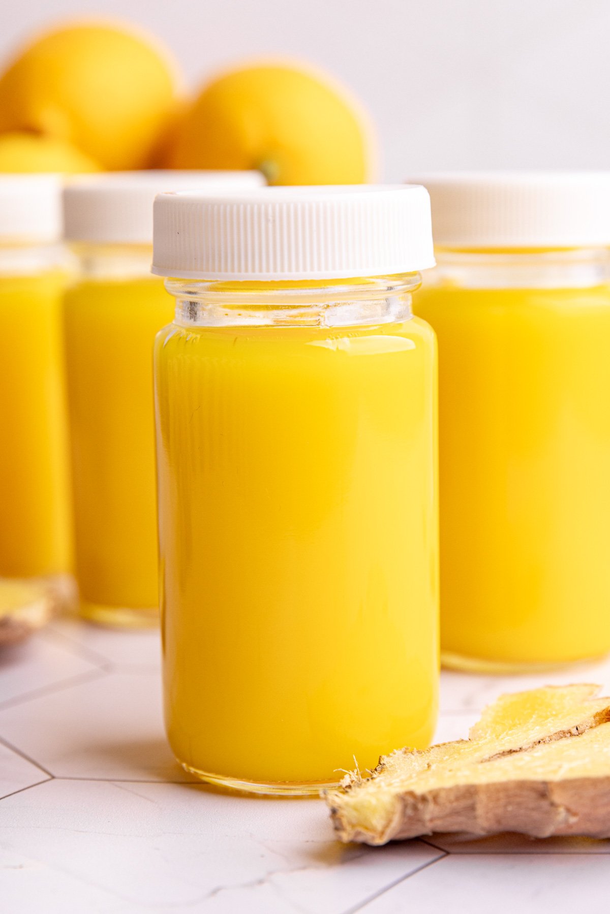 Homemade ginger shots in small juice shot glasses.