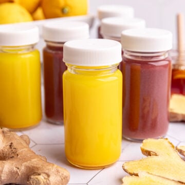 Homemade ginger and ginger elderberry shots in small juice shot glasses.