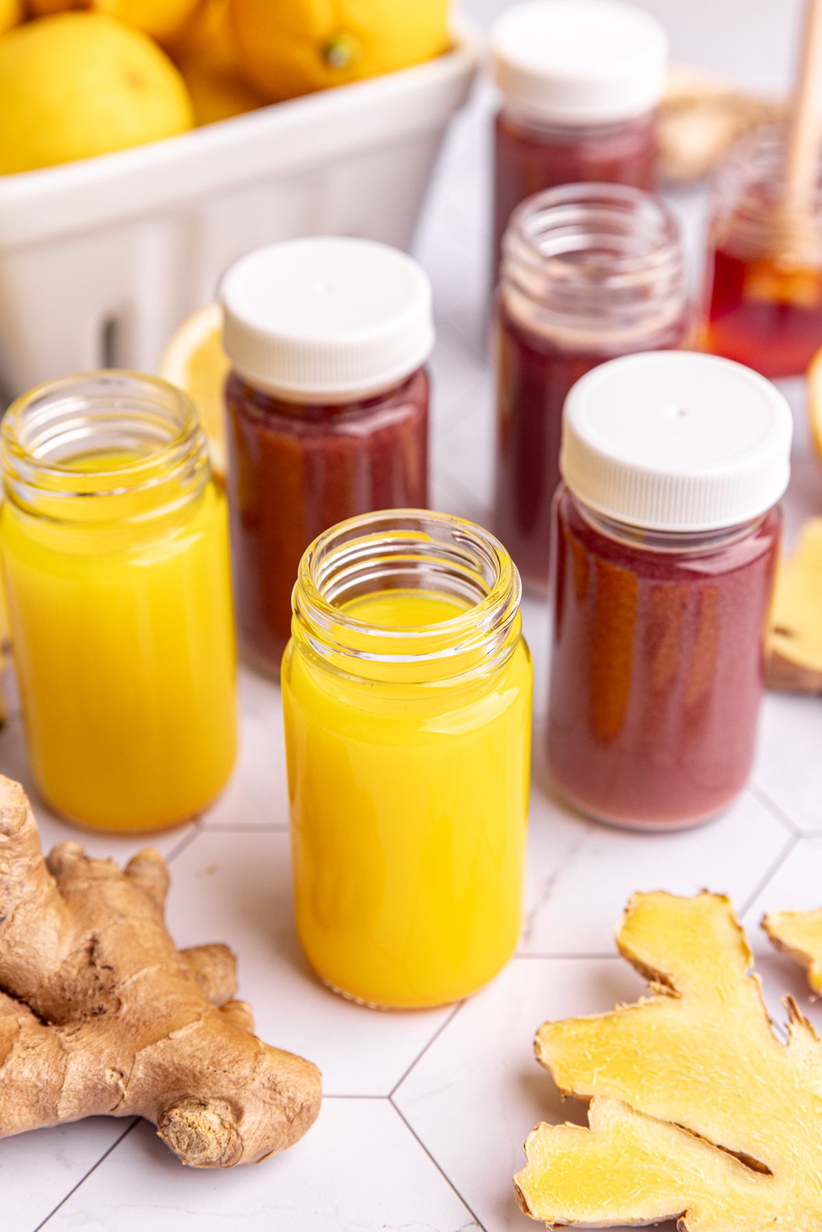 Homemade ginger and ginger elderberry shots in small juice shot glasses.