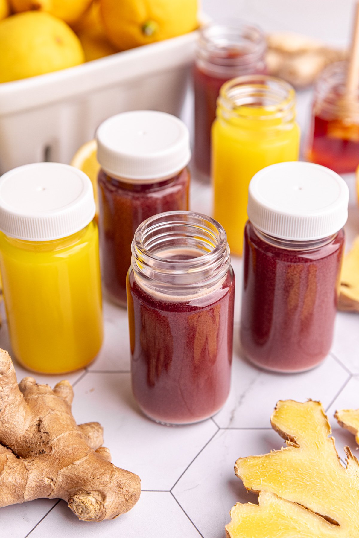 Homemade ginger and ginger elderberry shots in small juice shot glasses.