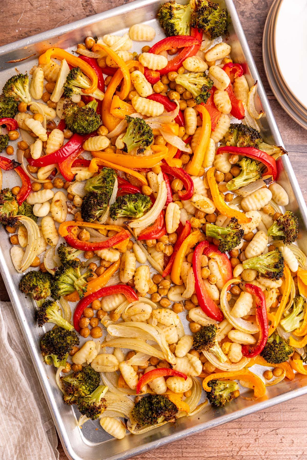 A sheet pan of freshly cooked gnocchi, chickpeas, and vegetables.
