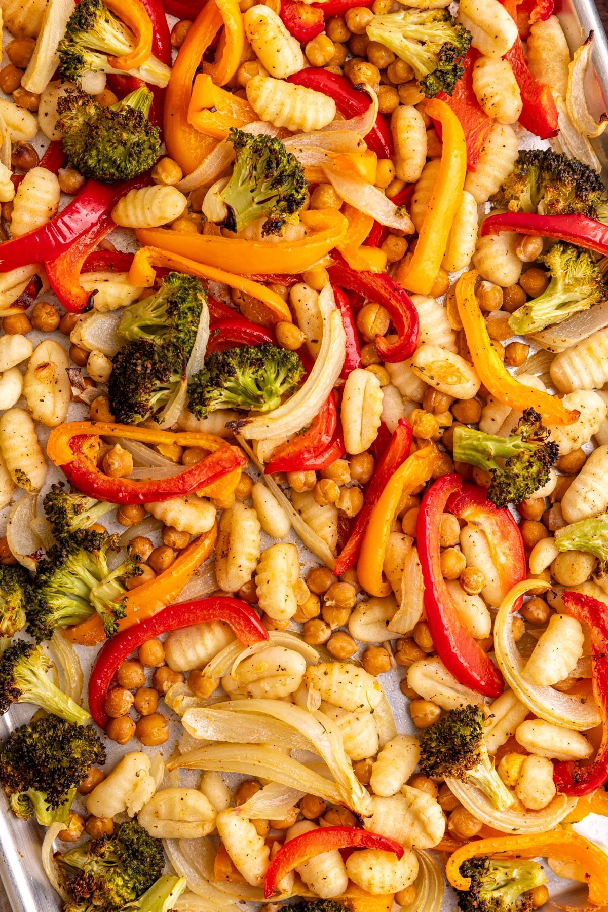 A sheet pan of freshly cooked gnocchi, chickpeas, and vegetables.