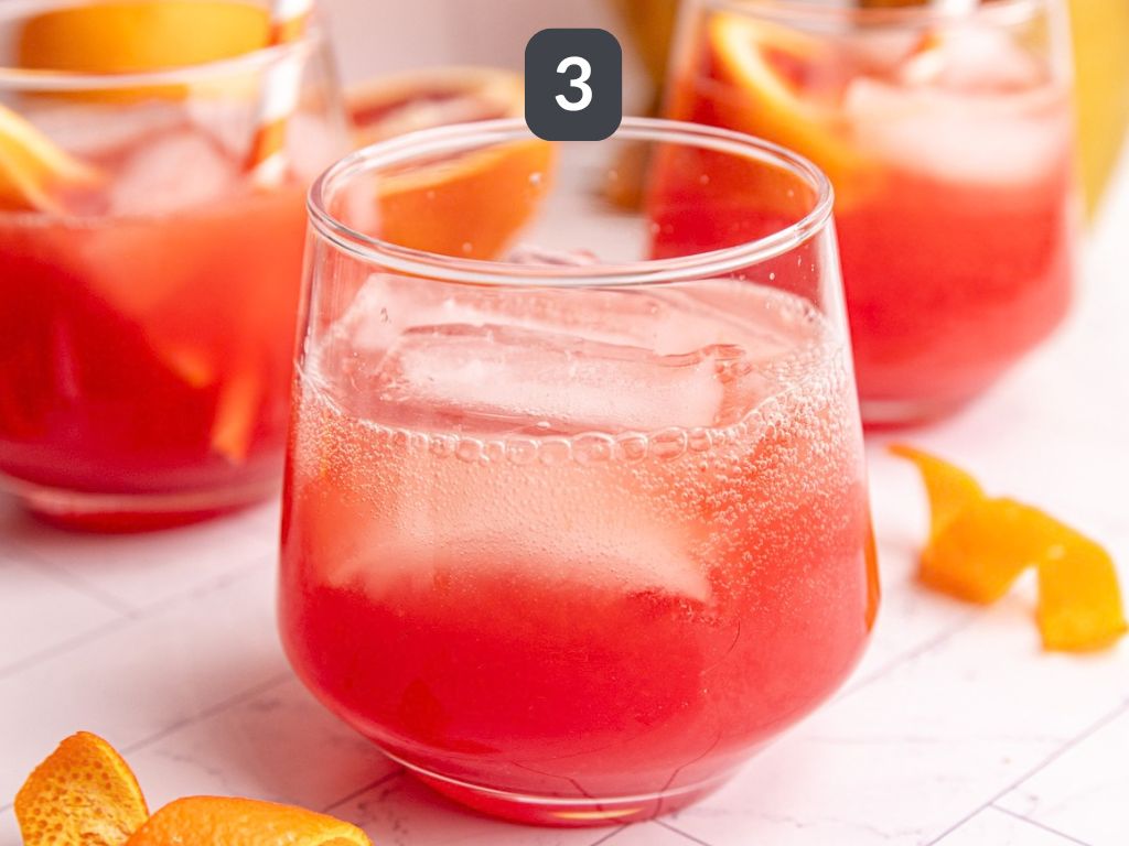 Aperol spritz mocktail step 3 - top with sparkling water