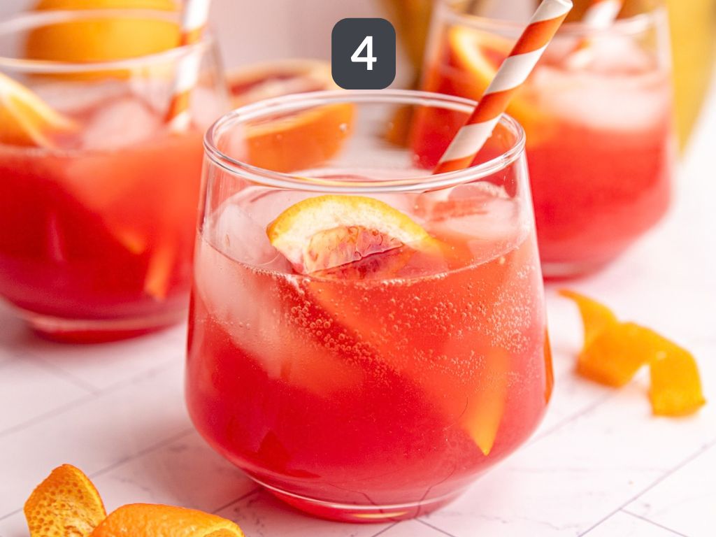 Aperol spritz mocktail step 4 - garnish with an orange wedge or twist, and a straw if desired