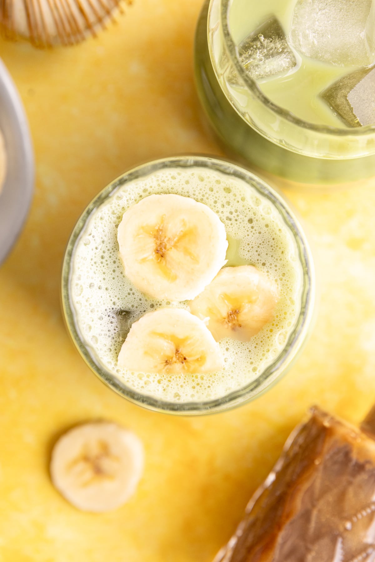 A banana cream matcha latte, with a few banana slices on top.