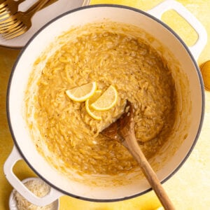 A pot of freshly cooked Creamy Lemon Orzo, topped with a few lemon slices.