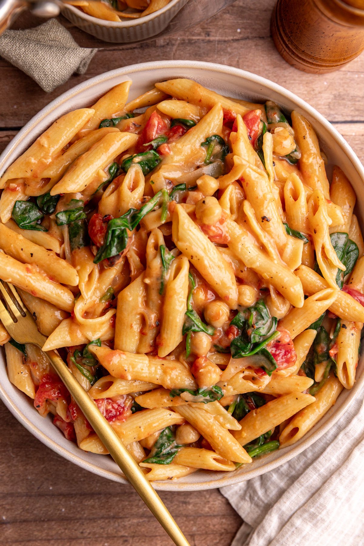 A bowl of one pot creamy tomato pasta, with a fork, ready to eat.