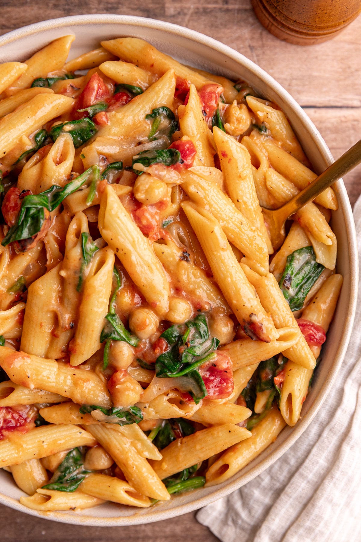 A bowl of one pot creamy tomato pasta, with a fork, ready to eat.