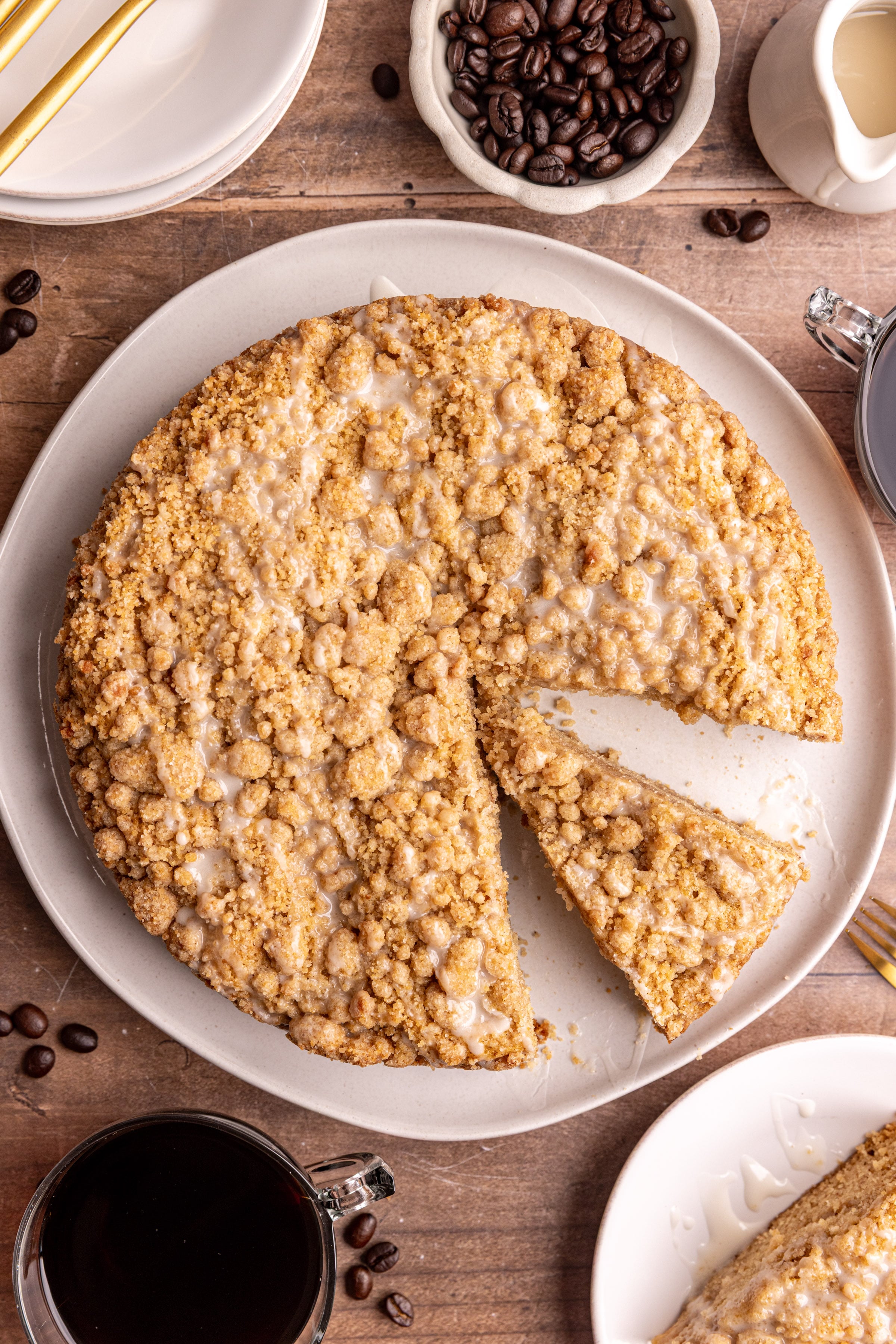 A platter of vegan cinnamon streusel coffee cake with a slice removed.