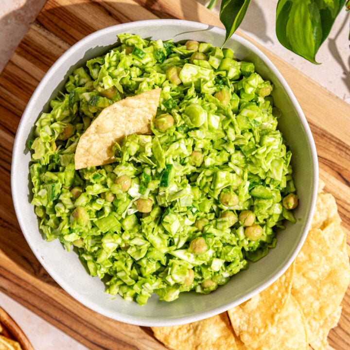 A bowl of Green goddess salad with chickpeas, with some tortilla chips.