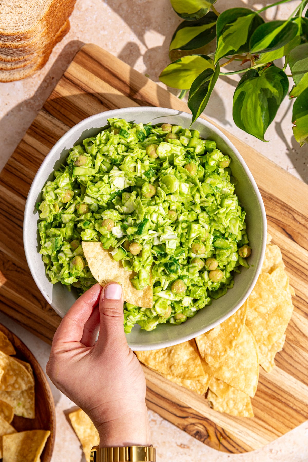 A bowl of Green goddess salad with chickpeas, with some tortilla chips.
