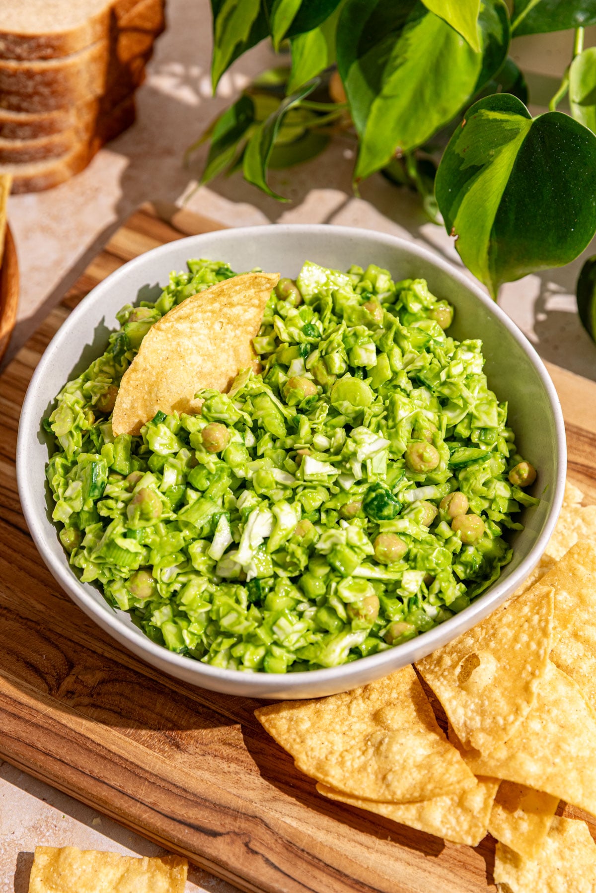 A bowl of Green goddess salad with chickpeas, with some tortilla chips.