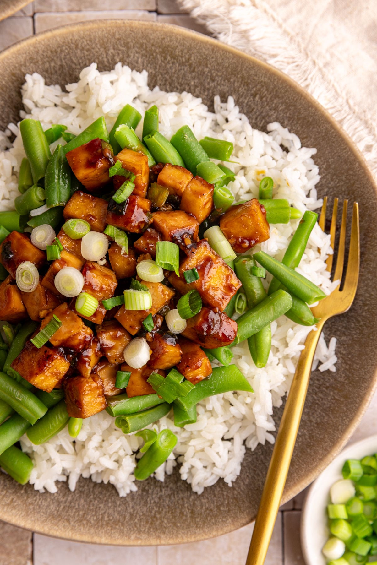 A plate of rice, Mongolian tofu, and green beans.