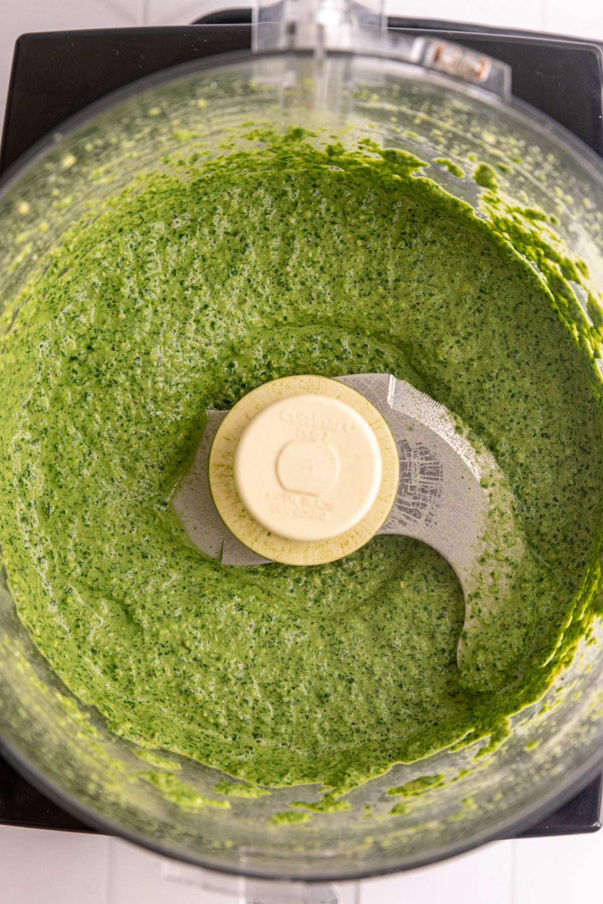 A food processor bowl of freshly blended vegan oil free pesto.