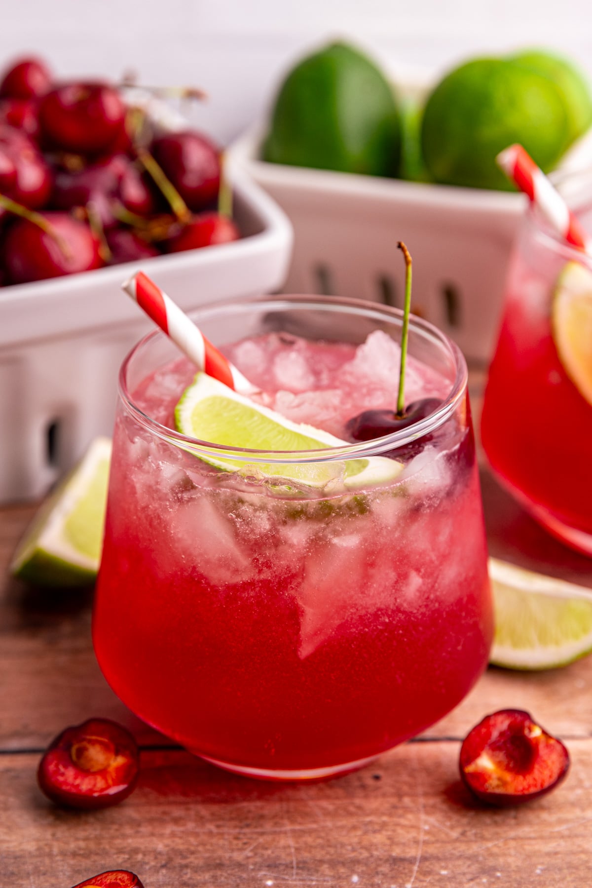 A cherry mocktail, garnished with a lime wedge and a cherry.