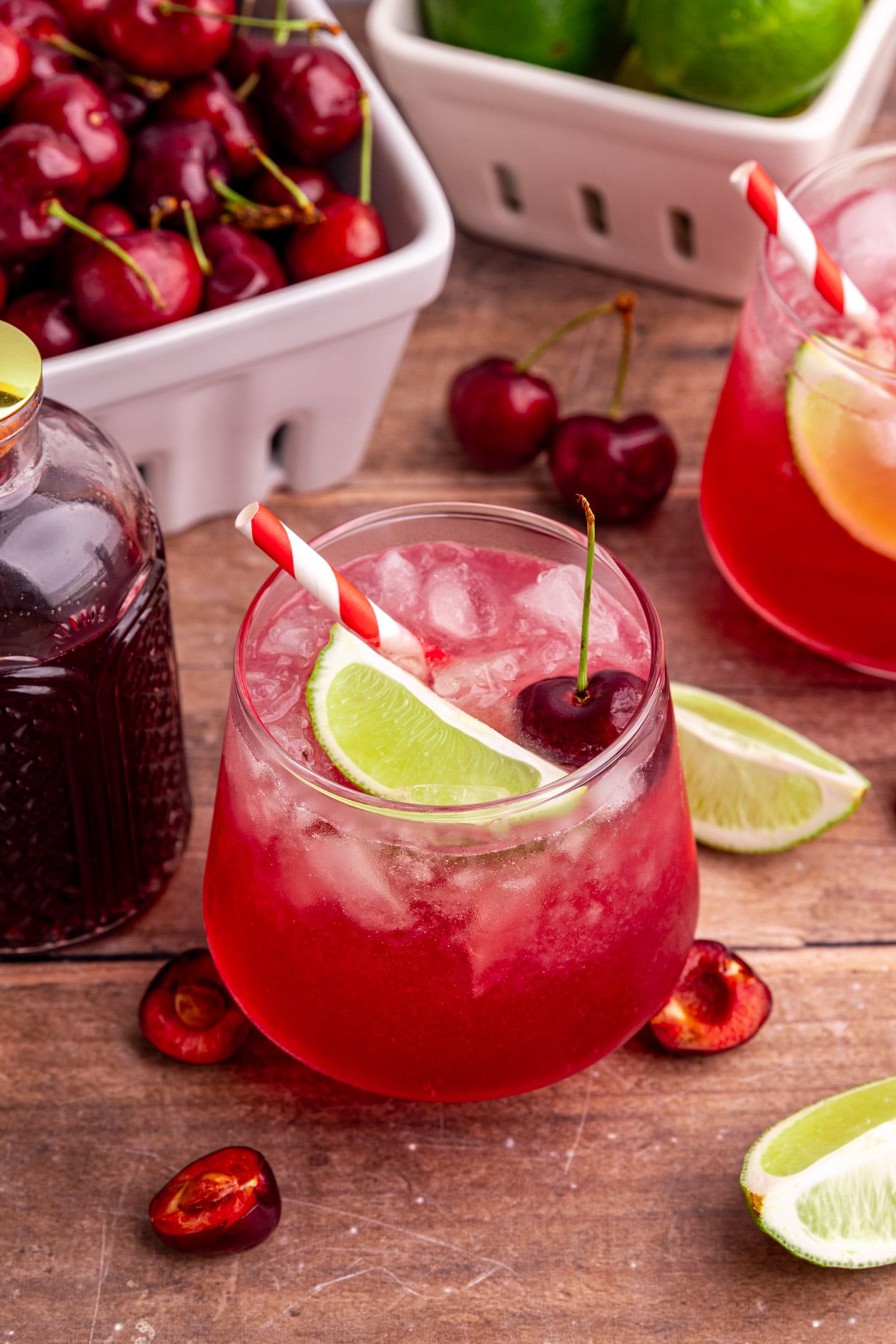 A cherry mocktail, garnished with a lime wedge and a cherry.