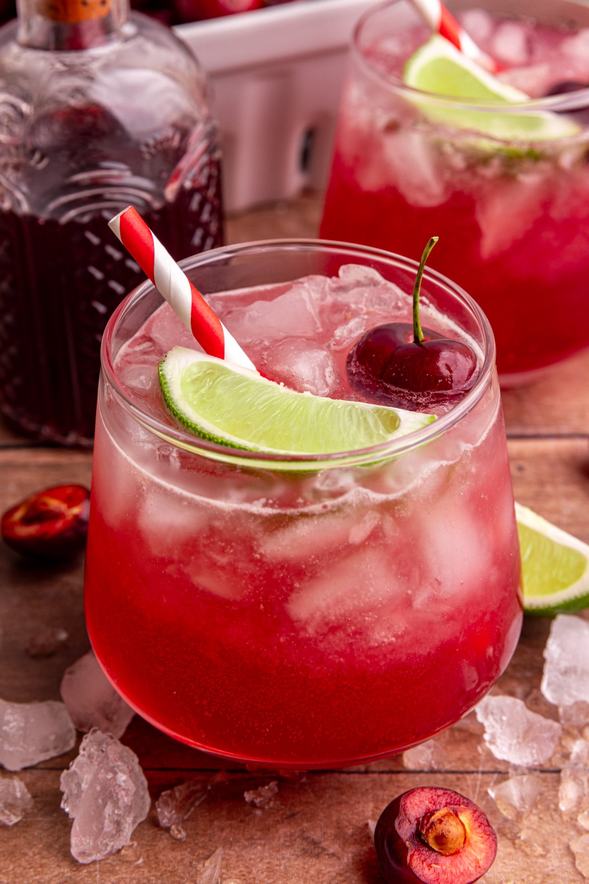 A cherry mocktail, garnished with a lime wedge and a cherry.