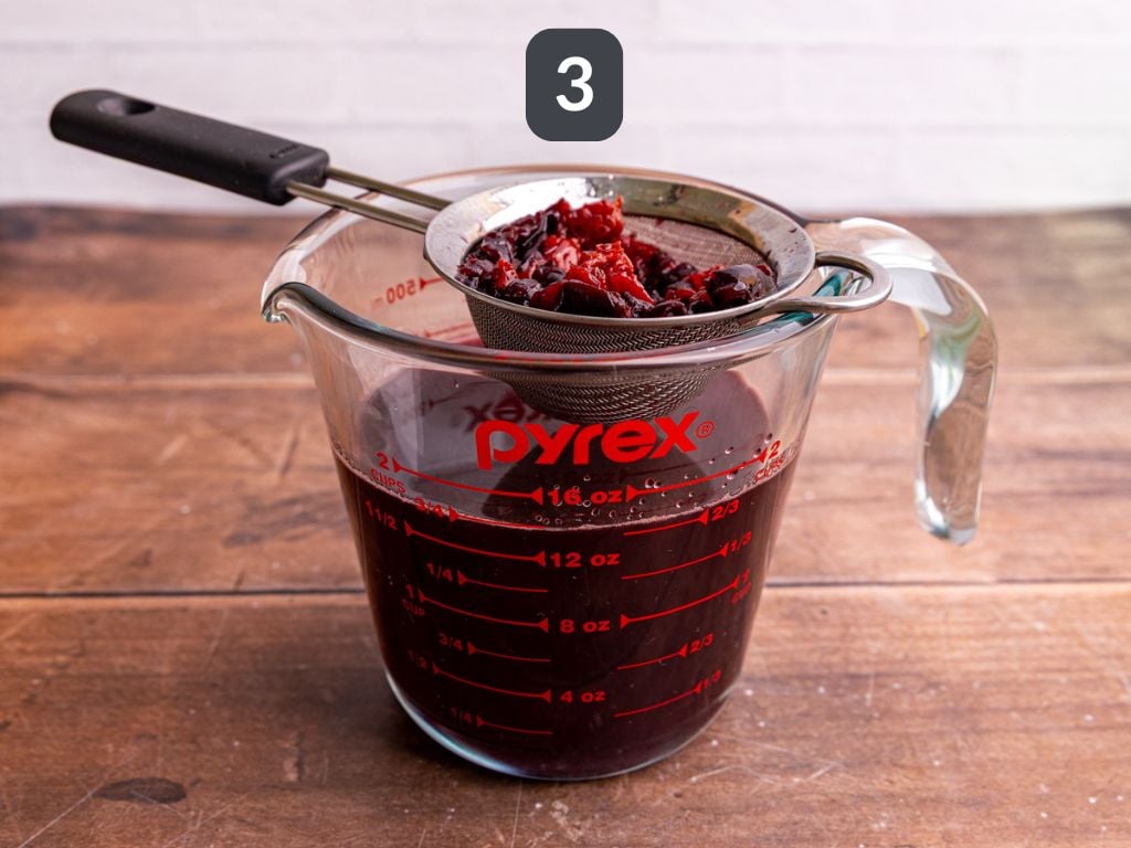 Cherry Simple Syrup Step 3 - strain out the cherry pieces.