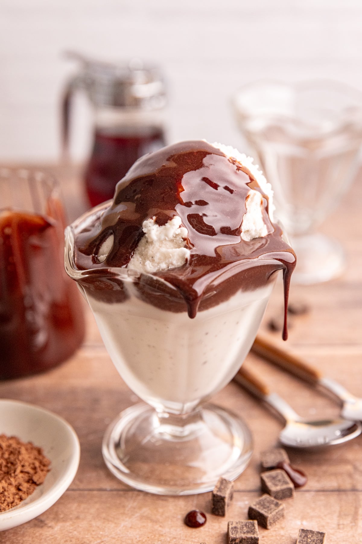 Maple chocolate syrup dripping off of a bowl of ice cream.